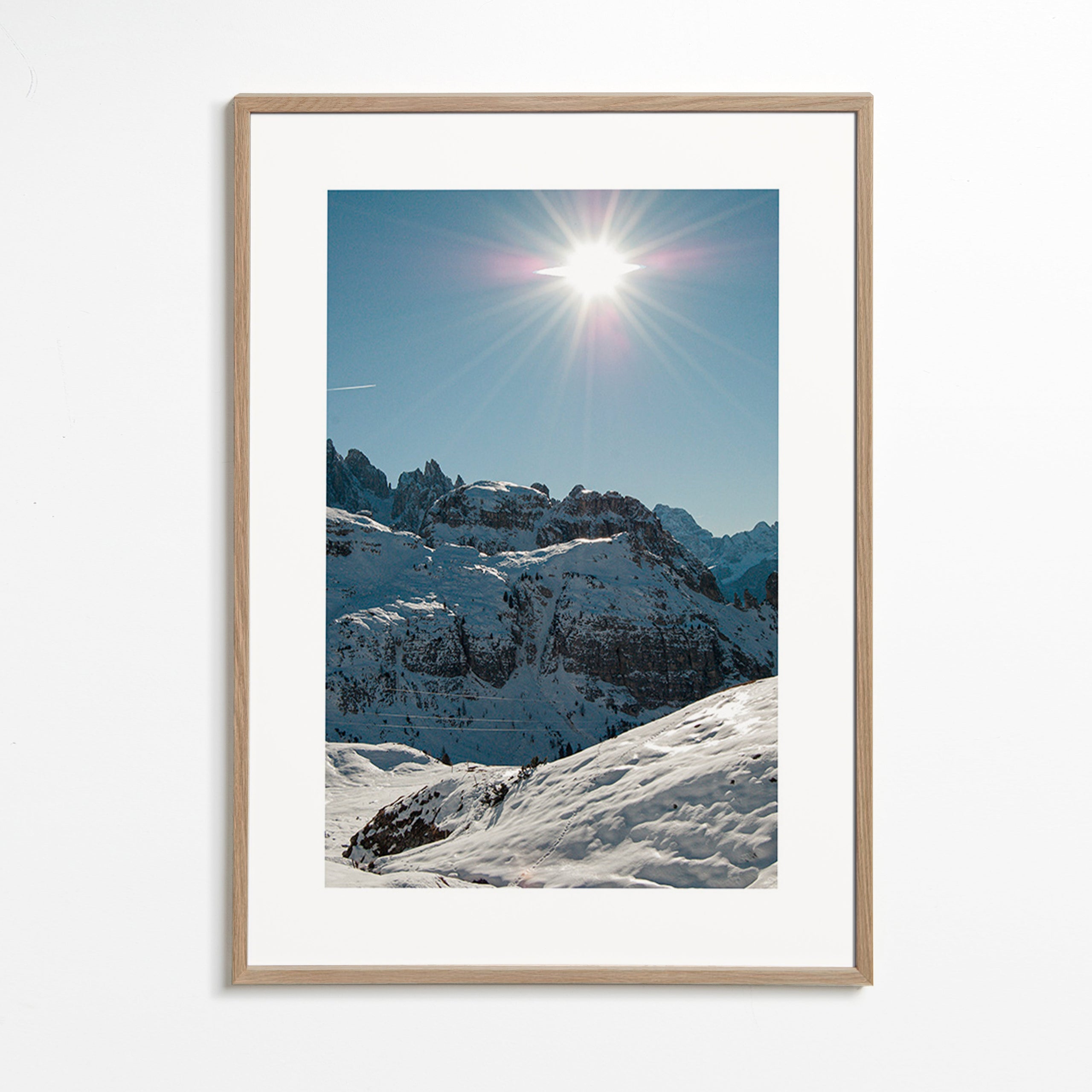 Küstenlandschaft: verschneite Gipfel mit strahlender Sonne