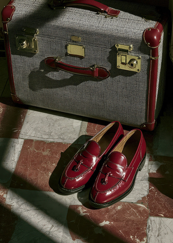 Reisefotografie mit Vintage-Koffer und roten Schuhen