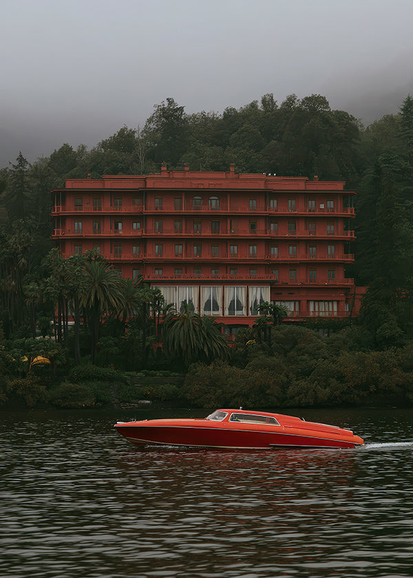 Landschaftsbild mit rotem Hotel und Schnellboot